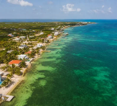 Aerial view of beachfront properties and blue ocean in a Belize coastal town