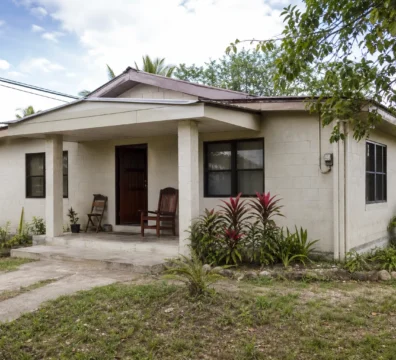 Modest concrete home typical of affordable mainland Belize property under $100,000